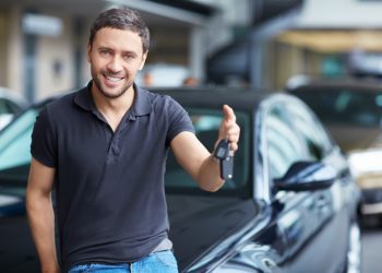 Young man with the keys at the car