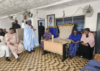Dr. Umar Ganduje at the Alarere residence of the late Oba Balogun holding the microphone while the three surviving Oloris-Olayinka, Olufunmilayo and Khalimat of the late monarch looks on.
