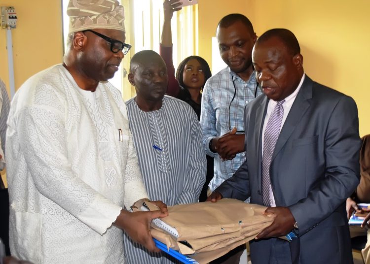 The Secretary to the Oyo State Government, Mr. Olalekan Alli receiving the project documents at the handing over of buildings donated by CBN to TechU, Ibadan from the CBN Branch Controller, Lagos Branch, Mr. Omebere Iyari on Thursday in Ibadan.