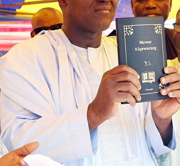 Speaker Yakubu Dogara  
 holding the bible written in Tera Language Bible in Yamaltu Deba, Gombe state."