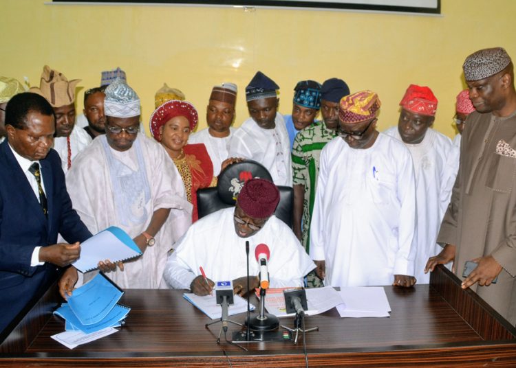 Ekiti State Governor, Dr Kayode Fayemi signing the 2019 Budget , surrounded by members of the State Assembly and state executive Council, at the Executive Chamber, Governor's office, Ado-Ekit...on Thursday