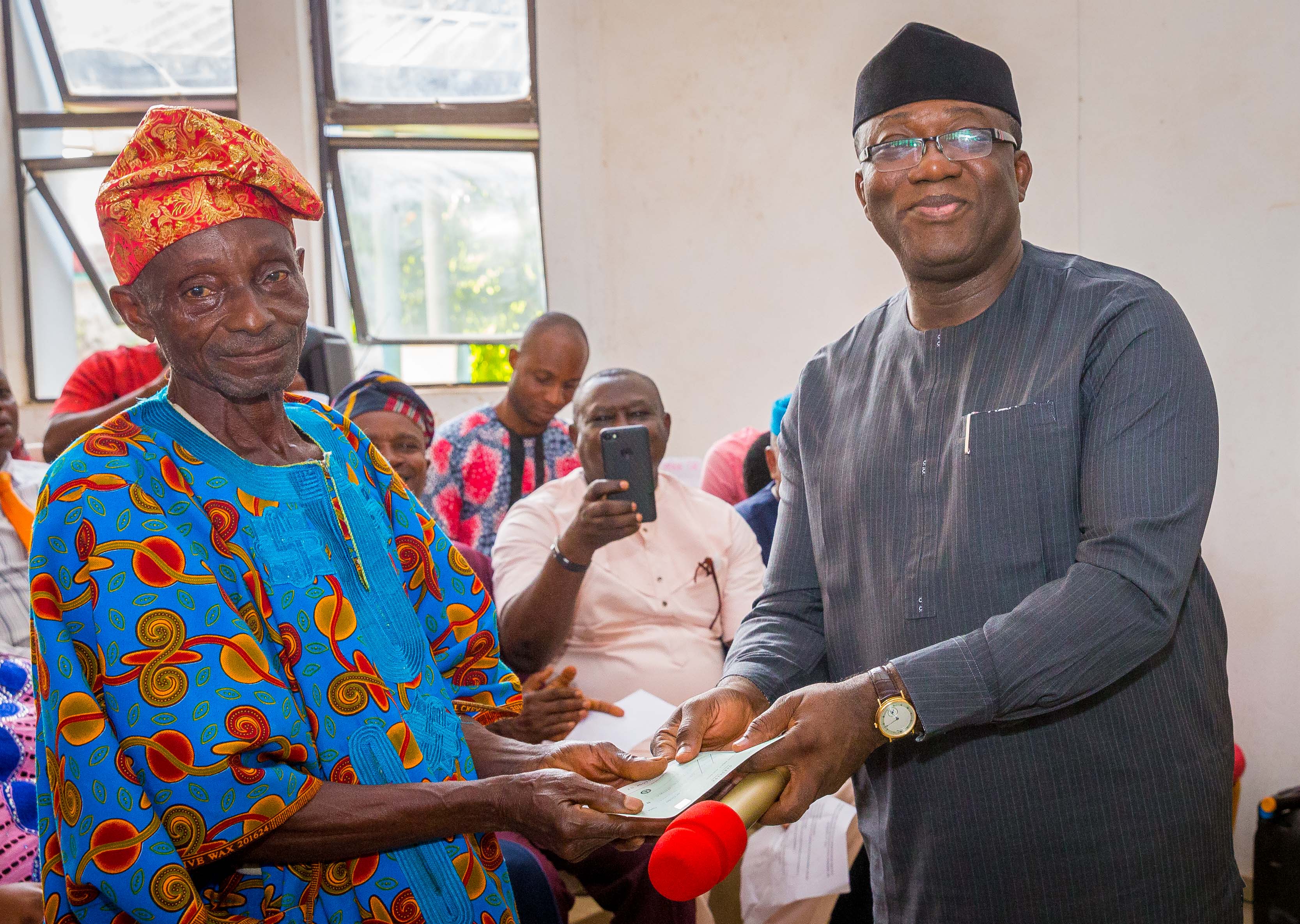 Ekiti State Governor, Dr Kayode Fayemi presenting  a cheque to a retiree, Mr. Olowofela Francis, during the presentation of gratuity cheque to local government and primary school pensioners in Ado-Ekiti…on Wednesday