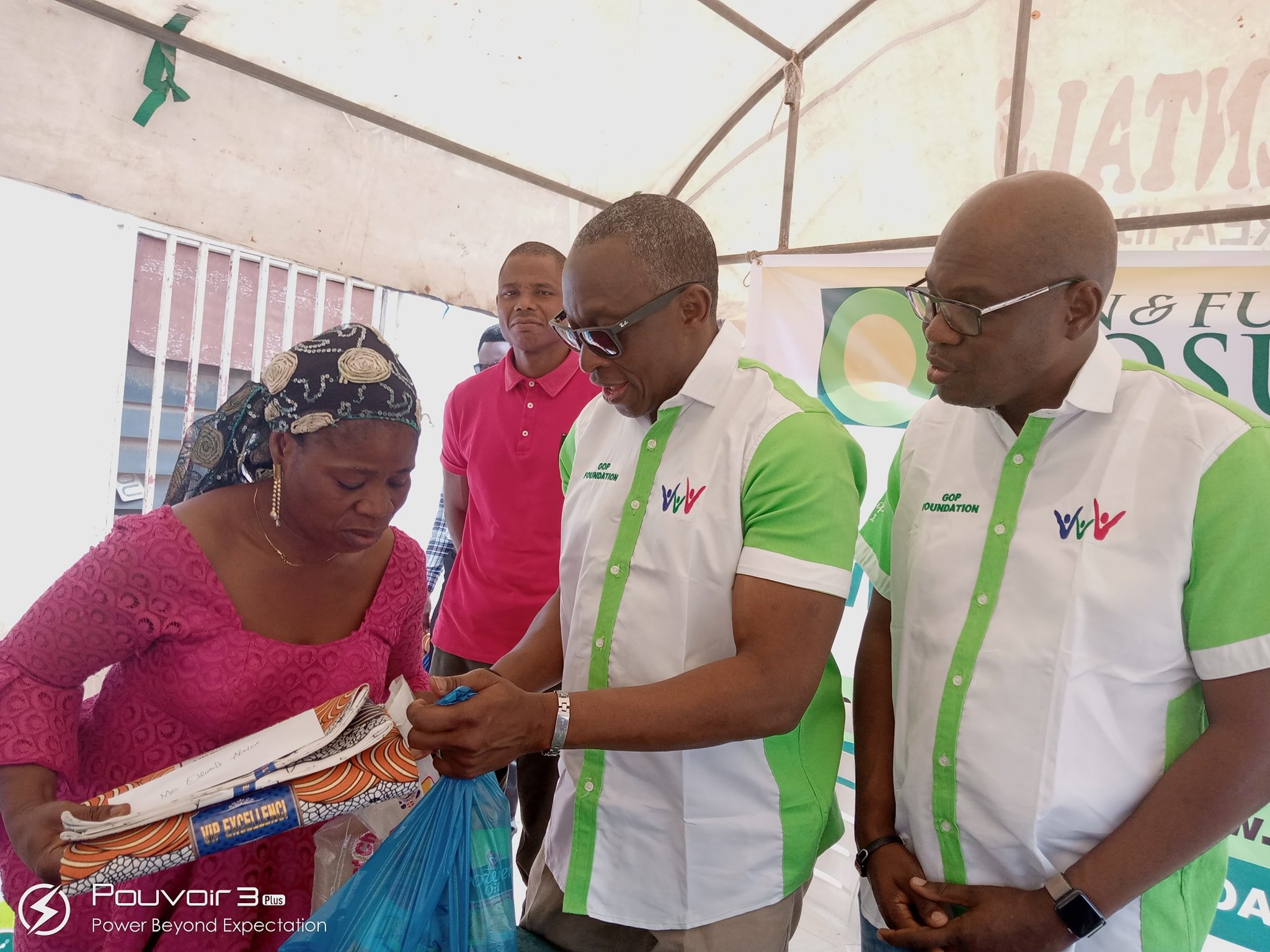 Pastor Akin Olaosun presenting empowerment materials to one of the beneficiaries while Pastor Kayode Oluremi of Kent Homes watches