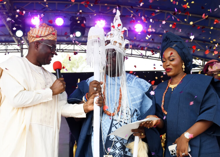 Oyo State Governor, Seyi Makinde (left); presenting staff of office to the new Aseyin of Iseyin, Oba Sefiu Olawale Oyebola, while his wife, Olori Mariam looks on, during the official coronation and presentation of staff of office to Aseyin. PHOTO: Oyo Gov's Media