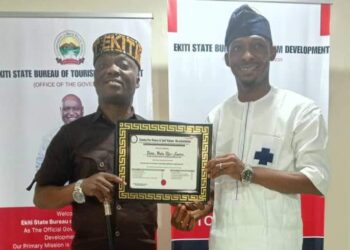 Mr Abraham Oyibo, Director Centre for Peace and Self Value Re-orientation presenting Award to Amb Wale Ojo Lanre in his Office