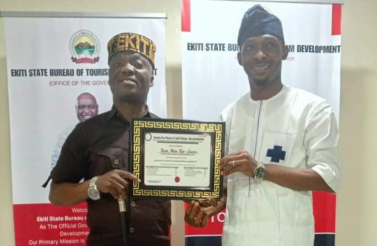 Mr Abraham Oyibo, Director Centre for Peace and Self Value Re-orientation presenting Award to Amb Wale Ojo Lanre in his Office