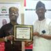 Mr Abraham Oyibo, Director Centre for Peace and Self Value Re-orientation presenting Award to Amb Wale Ojo Lanre in his Office