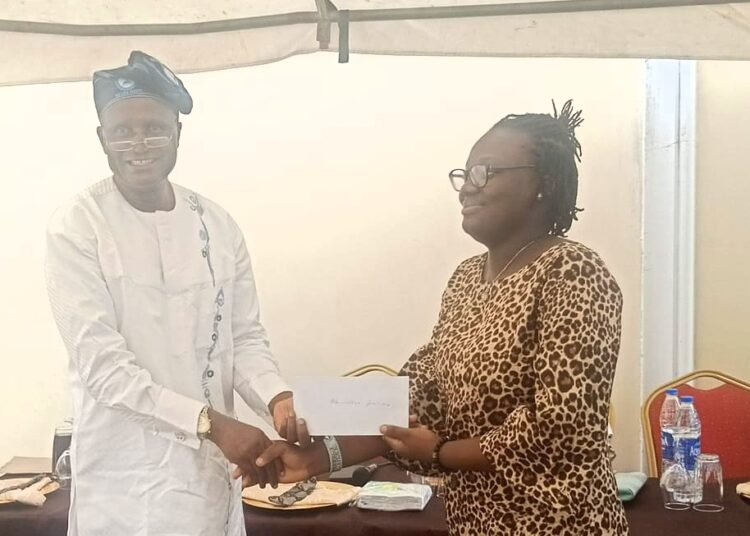 Prof.Duro Oni, president of The Ijesa Society,presenting of the Awards to Miss Ademosoye Precious, a 200level student of Mass Communication, UNILAG.