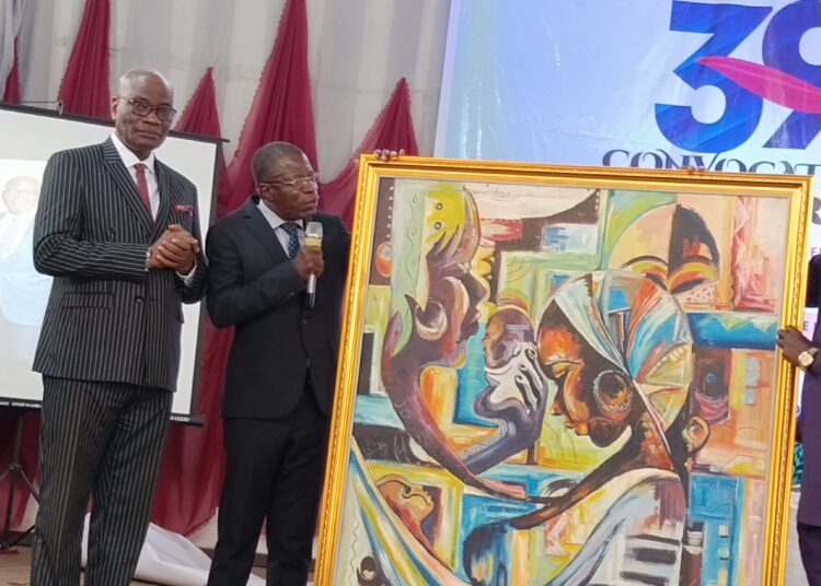 The acting Rector of The Polytechnic Ibadan, Dr Lasisis Taiwo explaining the drawing on the giant gramp resented to Professor Oluwatoyin Ogundipe after presentation of his paper at the Assembly Hall of the institution on Wednesday.