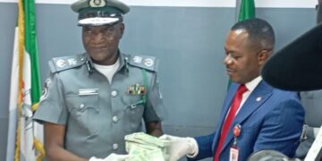 Customs’ Area Comptroller for the Command, Comptroller Mohammed Shuaibu handing over the CFA 7million exhibit to the EFCC’s Head of Investigation, Lagos Zone 2, at Idiroko, an Assistant Commander of EFCC, Oguzi Moses