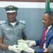 Customs’ Area Comptroller for the Command, Comptroller Mohammed Shuaibu handing over the CFA 7million exhibit to the EFCC’s Head of Investigation, Lagos Zone 2, at Idiroko, an Assistant Commander of EFCC, Oguzi Moses